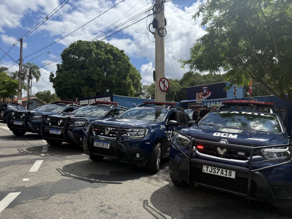 A imagem mostra uma frota de viaturas da Guarda Civil Municipal (GCM) de Franco da Rocha estacionadas em fila diagonal em uma via pública, sob um céu parcialmente nublado. Os veículos são SUVs de cor azul-marinho, modelo Renault Duster, equipados com giroflex, grades de proteção frontal (quebra-mato) e identificações específicas, como a inscrição 