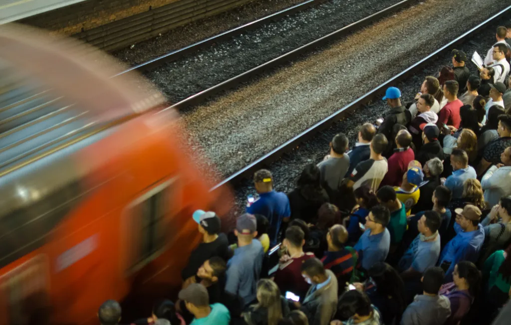 Passageiros aguardando trem na plataforma de uma estação
