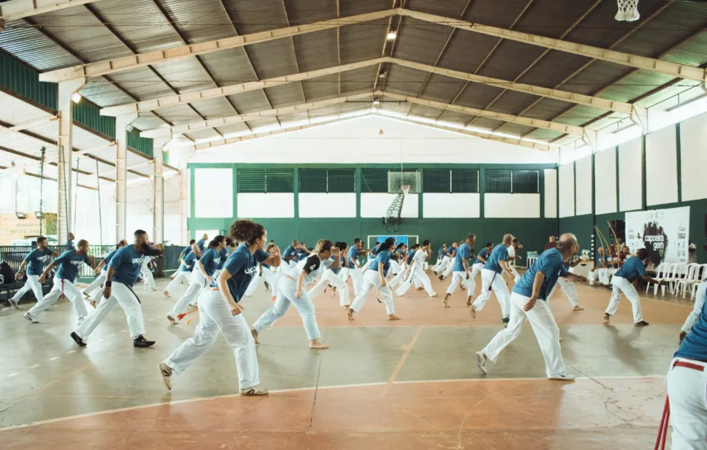 Pessoas praticando capoeira em um ginásio