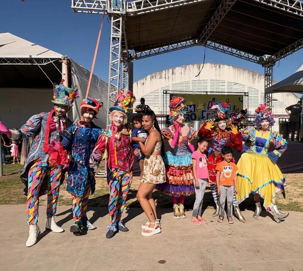 Grupo de animadores infantis posam para fotos com pais e crianças durante um evento voltado ao público infantil no parque municipal de Franco da Rocha