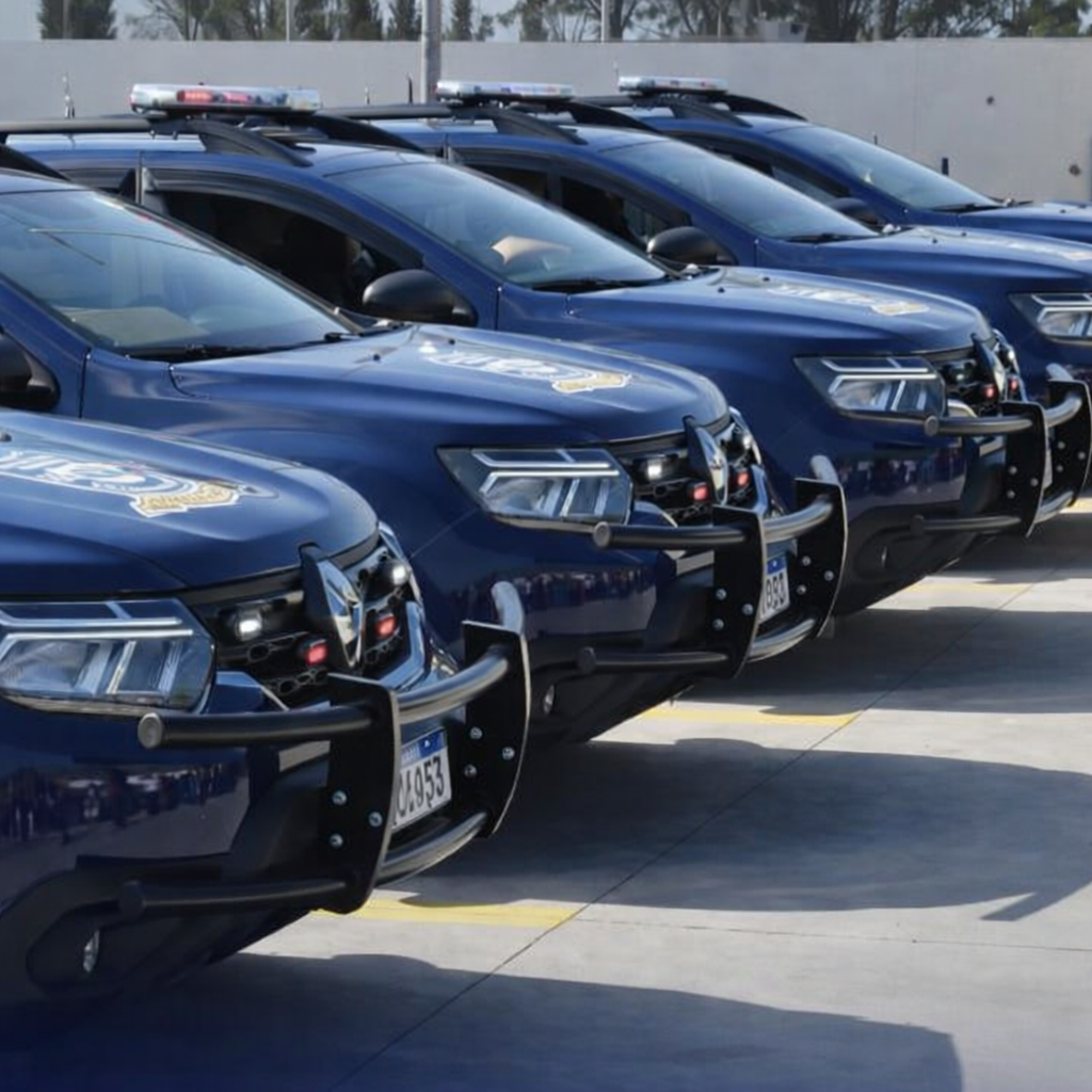 Fila de viaturas da Guarda Civil Municipal de Francisco Morato estacionadas lado a lado em um pátio ensolarado, todas na cor azul escura com luzes de emergência no teto e para-choques reforçados, formando uma composição simétrica que destaca a organização e prontidão da corporação.