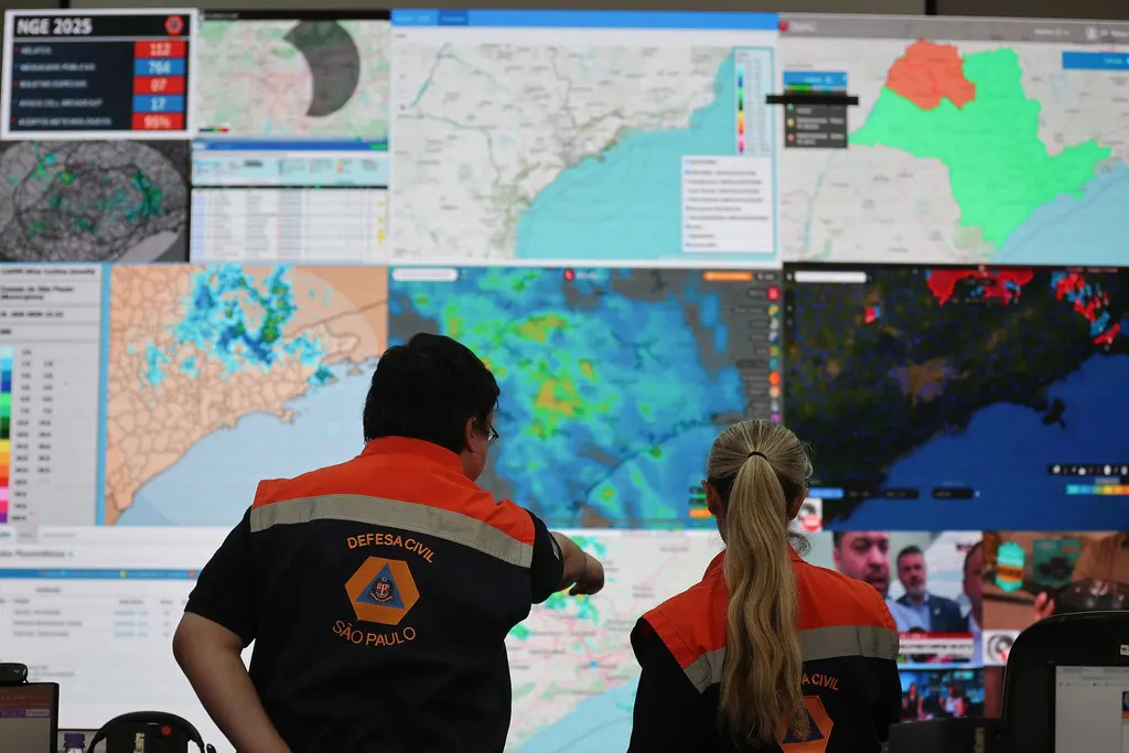 Imagem mostra agentes da Defesa Civil de São Paulo em uma central de monitoramento