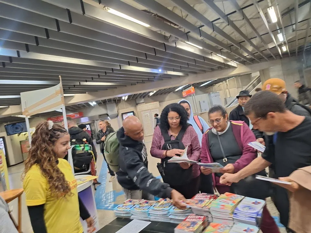 Imagem mostra a distribuição gratuita de livros em uma estação de trem