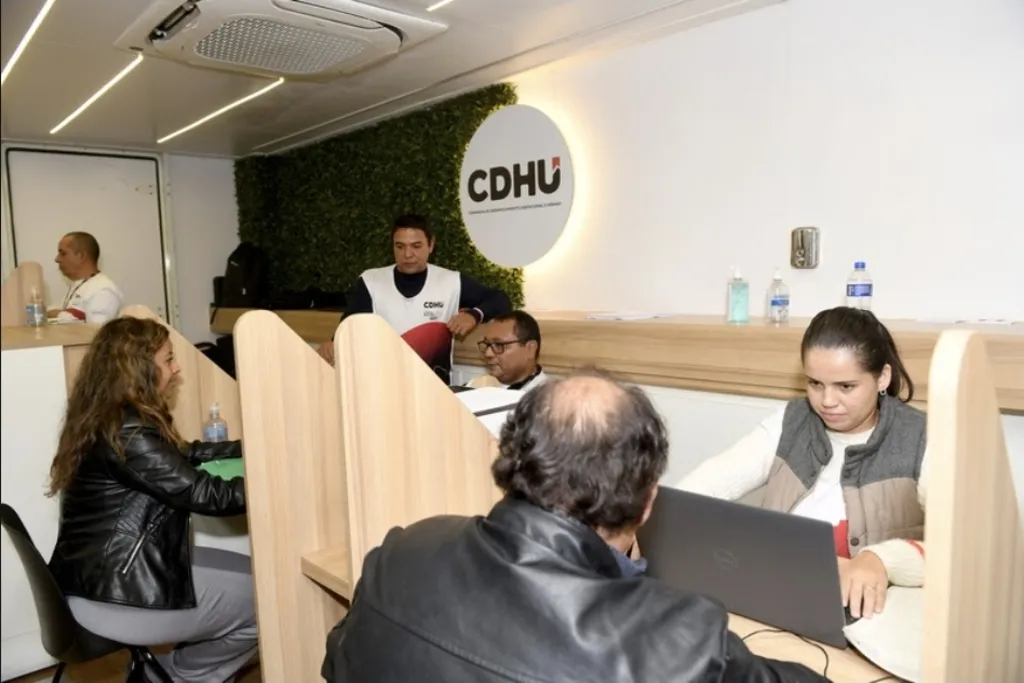 Pessoas sendo atendidas por funcionários da CDHU